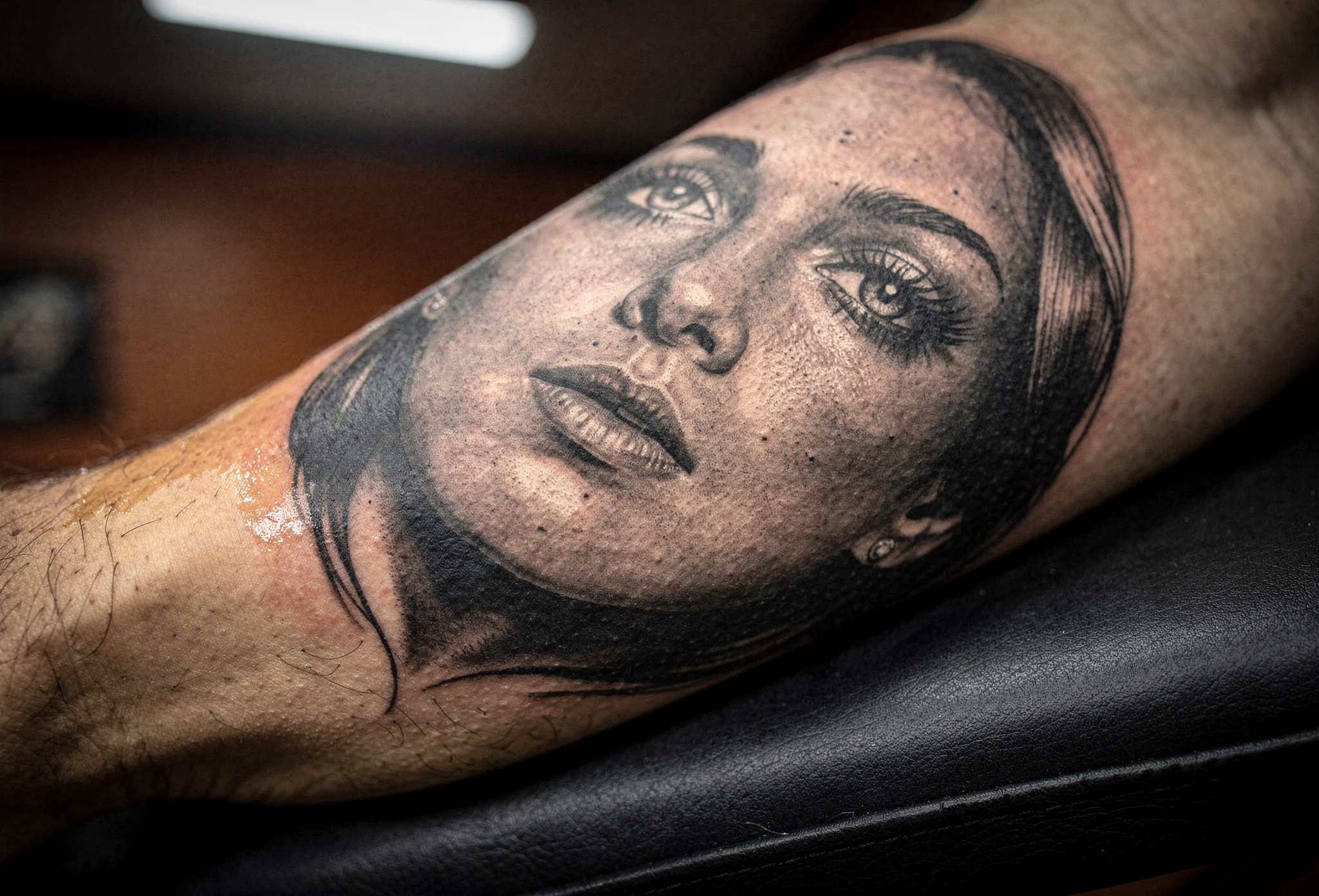 Kol üzerinde gerçekçi kadın portre dövme detayı